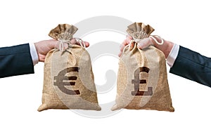 Currency exchange concept. Hands holds bags full of money - British pounds and Euro