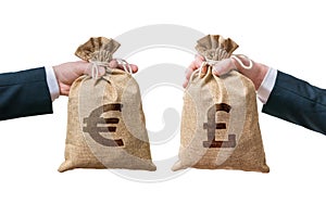 Currency exchange concept. Hands holds bags full of money - British pounds and Euro photo