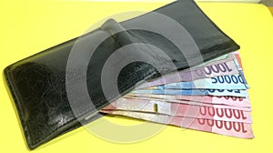 The Currency Money Rupiah Banknote in the wallet in the room with Yellow Background