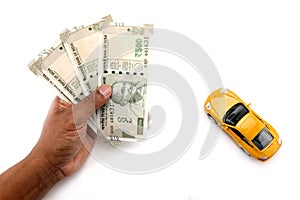 Indian currency notes and toy car in the hands bank loan concept