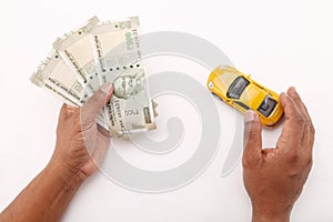 Indian currency notes and toy car in the hands bank loan concept