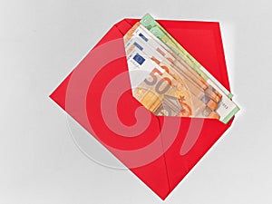 Currency in red envelope on white background