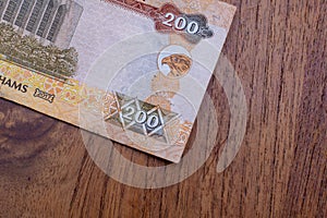 The Currency of the United Arab Emirates UAE - Close up of a two hundred Dirham note  on a brown table background. Money