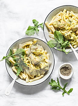 Curried creamy salmon with pasta on a light background, top view