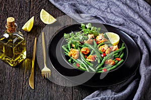 Curried salmon with green beans on a black plate