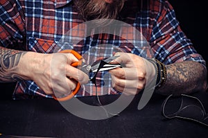 Currier of leather demonstrates leather cutting process in his leather studio