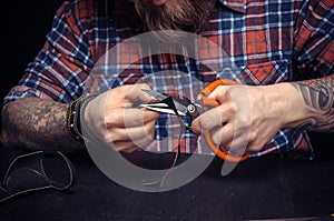 Currier of leather demonstrates leather cutting process in his leather studio