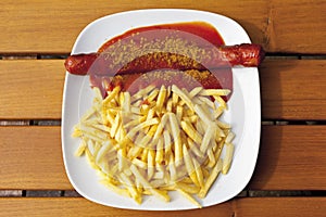 Curry sausage with chips in plate