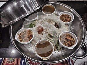 Curry with vegetables and meat in a pan on a table in a restaurant