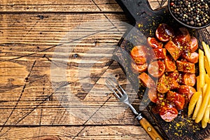 Curry wurst Sausages with French fries on a wooden board. wooden background. Top view. Copy space