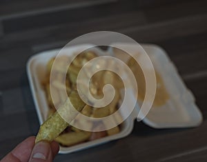 currywurst with fries into a cup. traditional german food to go with dip at corona times, focus on frie in hand photo