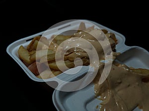 currywurst with fries into a cup. traditional german food to go with dip at corona times, negative space photo