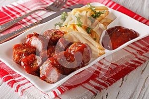 Currywurst sausage with french fries close-up. Horizontal