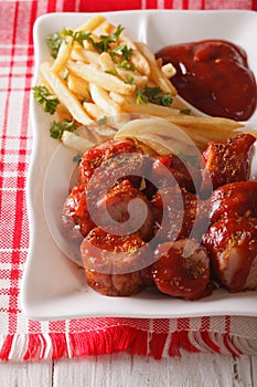 Currywurst sausage with french fries close-up. vertical