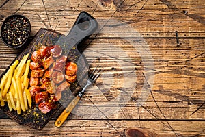 Currywurst Sausages street food served French fries on a wooden board. wooden background. Top view. Copy space