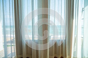 Curtain and glass window with sea beach view outside