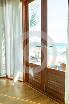 Curtain and glass window with sea beach view outside