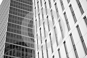 Curtain wall made of toned glass and steel constructions under sky. A fragment of a building. Black and white.