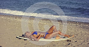 Curvaceous young woman sunbathing on a beach