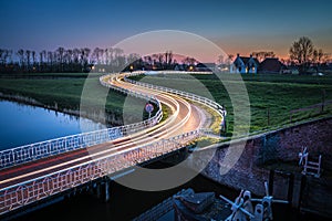 Curve light trails on country road in the landscape of the province of Groningen, The Netherlands