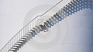 Curve line spiral staircase on storage fuel tank with sunlight and shadow on surface