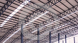 Curve metal roof beam structure with aluminium corrugated steel roof and skylights inside of large industrial warehouse building