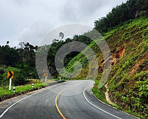 Curve road sign near mountain