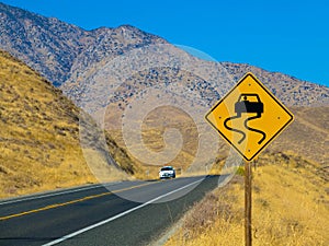 Curved ahead warning sign on highway road