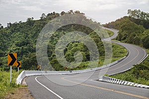 Curved asphalt road with sign curves in the mountains