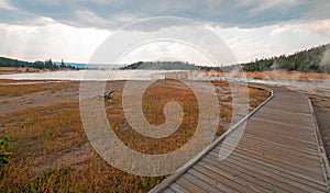 Curved Elevated wooden boardwalk going past Black Warrior Hot Springs and Tangled Creek into Hot Lake in Yellowstone National Park