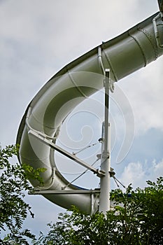 Curved Giant Water Slide with Green Foliage - Ground Up View