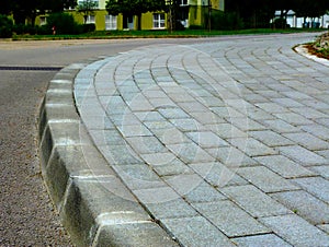 Curved interlocking concrete paved sidewalk closeup. running bond.
