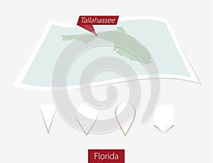 Curved paper map of Florida state with capital Tallahassee on Gr