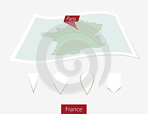 Curved paper map of France with capital Paris on Gray Background