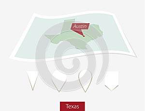 Curved paper map of Texas state with capital Austin on Gray Back