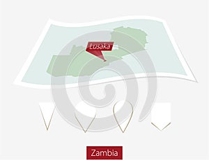 Curved paper map of Zambia with capital Lusaka on Gray Background. Four different Map pin set.