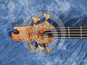 Curved patterned wood bass guitar headstock