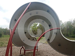 Curved playground climbing structure wall with hand and foot holds