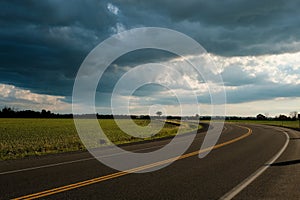 Curved road with dramatic summer storm clouds photo