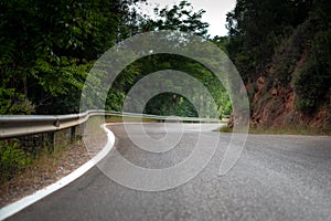 A curved road in the forest with white lines