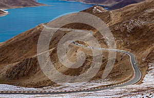 Curved road on the mountain alongside Yamdrok Lake