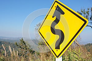 Curved road sign with the sky as a background