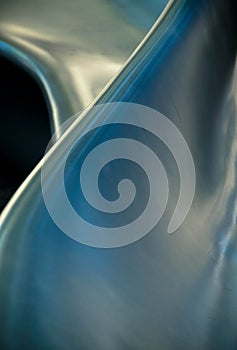 Curved smooth blue and silver metal forms abstract art