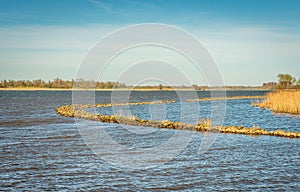Curved stone groyne in a wide river