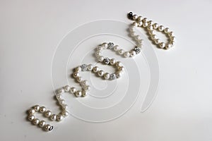 Curved string of pearls on a white background