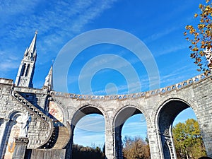 Curved top walkway to Upper Immaculate Conception Basilica of Sanctuary of Our Lady of Lourdes with Large Arches below