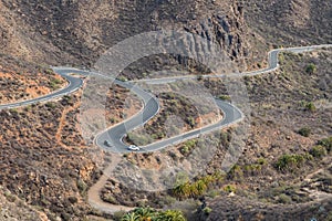 Curved winding road with two cars driving in the mountains in Gran Canaria