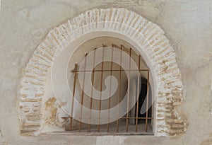 Curved window of pale stone in a wall