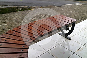 Curved Wooden Bench on Tiled Pavement