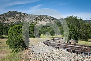 Curves of rusty rails in midden of nature